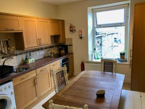 a kitchen with a wooden table and a window at Stunning Aberystwyth South Beach Apartment in Aberystwyth