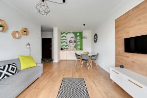 a living room with a couch and a table with chairs at Modern Old Town - Apartament w centrum Gdańska by Grand Apartments in Gdańsk