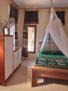 um quarto com uma cama e uma rede mosquiteira em FRANGKY HOMESTAY em Manado