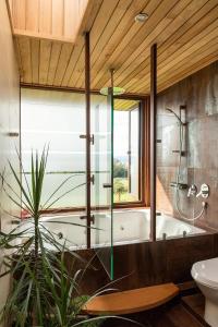 y baño con bañera y ducha acristalada. en Lujosa Casa Altamira - Villarrica, en Villarrica