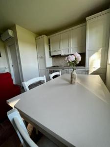 a kitchen with a table with a vase of flowers on it at Agriturismo Fattoria Primaluce - Appartamento Quercia in Spino dʼAdda