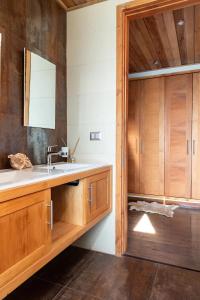 y baño con lavabo y armarios de madera. en Lujosa Casa Altamira - Villarrica, en Villarrica