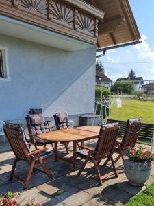 einen Holztisch und Stühle auf einer Terrasse in der Unterkunft Ferienwohnung Ramsbacher in Velden am Wörthersee