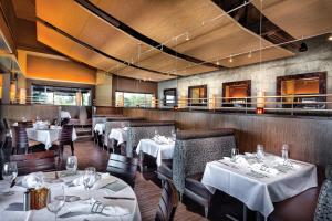 a restaurant with tables and chairs with white tablecloths at Club Wyndham Oceanside Pier Resort in Oceanside