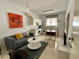 a living room with a couch and a table at Cosy one bedroom apartment in Pafos in Paphos City