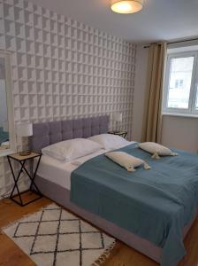 DOWA Apartments Thaliastrasse في فيينا: غرفة نوم بسرير كبير مع بطانية زرقاء