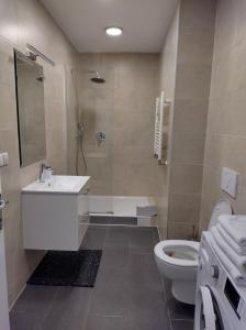 DOWA Apartments Thaliastrasse في فيينا: حمام مع حوض ومرحاض