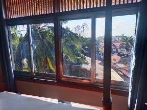 a bedroom window with a view of a palm tree at Serene Beach Resort in Dar es Salaam