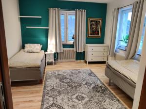 1 dormitorio con paredes verdes, 1 cama y 1 alfombra en Luxury accommodation 130 m2 en Katrineholm