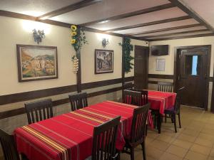 un restaurante con 2 mesas y sillas con manteles rojos en Asya Guest House, en Sapareva Banya