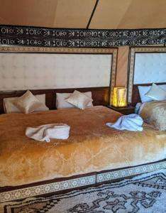 a bedroom with a large bed with towels on it at Luxury Desert Camp in Merzouga