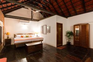 1 dormitorio con cama y banco. en Niyati - Boutique Stay, en Kochi