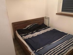 a bed with a blue and white comforter on it at Apartament przy Parku in Żywiec