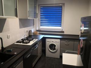 a kitchen with a stove and a washing machine at Apartament przy Parku in Żywiec