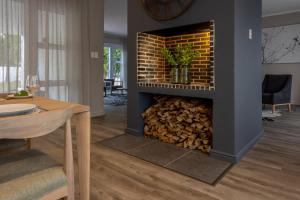 a fireplace in a living room with a pile of fire wood at Villa Stellenbosch in Stellenbosch