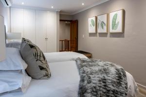 a bedroom with a white bed and some pictures on the wall at Villa Stellenbosch in Stellenbosch +36 photos
