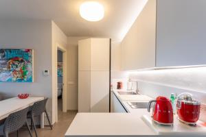 een keuken met witte kasten en een rood apparaat op een aanrecht bij Le Terrazze Baveno in Baveno