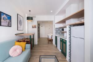 a living room with a blue couch and a kitchen at Wello Apartments Sevilla in Seville