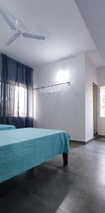 a bedroom with a blue bed and a window at Ola Goa in Mandrem