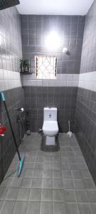 a bathroom with a white toilet in a tiled floor at Ola Goa in Mandrem