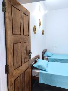 a door leading to a room with two beds at Ola Goa in Mandrem
