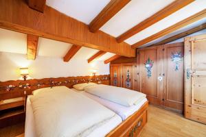 a bedroom with a large bed and wooden walls at Adang Ferienwohnung Mutspitz in Tirolo