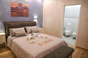 una camera da letto con un letto con due bambole sopra di Don Giovanni ad Alghero