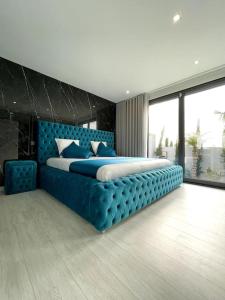 una camera da letto con un grande letto blu con testiera blu di Nova Mansão LA ad Arcozelo