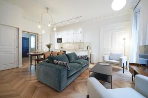 salon z zieloną kanapą i kuchnią w obiekcie Parisuites Central Grands boulevards Design Folies Bergères w Paryżu