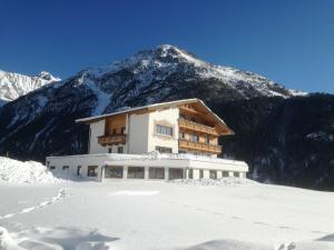 a building in front of a snow covered mountain at Appartement Belmonte in Sölden