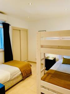 a bedroom with two bunk beds and a window at Sunny villa by the beach surrounded by pine trees in Vale do Lobo