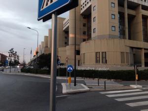 un panneau de rue devant un grand bâtiment dans l'établissement Executive center rooms, à Bari
