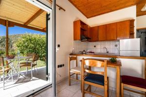 a kitchen with a table and chairs on a patio at Pantelios Village apartment 1 in Kefallonia