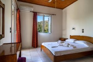 a bedroom with a bed and a window at Pantelios Village apartment 1 in Kefallonia