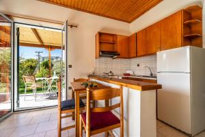 a kitchen with a refrigerator and a table with chairs at Pantelios Village apartment 1 in Kefallonia