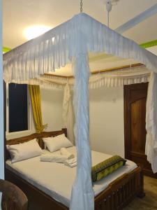 twee bedden in een kamer met een hemelbed bij Karibuni palace mtwapa in Mtwapa