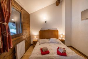 um quarto com uma cama com duas almofadas vermelhas em Au chalet du Nant d'ant em Samoëns