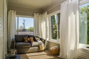 uma sala de estar com um sofá e duas janelas em Painted Hills em Portland