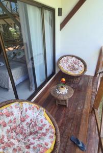 ein Balkon mit zwei gepolsterten Stühlen und einem Tisch in der Unterkunft Villas BobZ in Barrinha