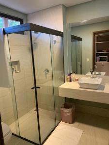 ein Badezimmer mit Glasdusche und Waschbecken in der Unterkunft Villas BobZ in Barrinha + 11 Fotos