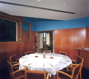 uma grande sala de jantar com uma mesa branca e cadeiras em Hostal Mallorquines em Riudarenes