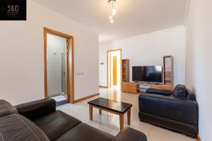 ein Wohnzimmer mit einem Sofa und einem TV in der Unterkunft Comfortable Penthouse, served with LIFT, WIFI & AC by 360 Estates in Gżira