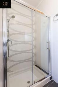 eine Dusche mit Glastür im Bad in der Unterkunft Comfortable Penthouse, served with LIFT, WIFI & AC by 360 Estates in Gżira