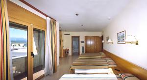 a row of beds lined up in a room at Hostal Mallorquines in Riudarenes