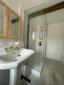 a white bathroom with a sink and a shower at Beautiful listed 3 bedroom cottage with wood burner in Youlgreave