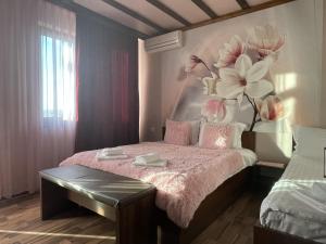 サパレヴァ・バニャにあるAsya Guest Houseのベッドルーム1室(花の絵が飾られたベッド1台付)