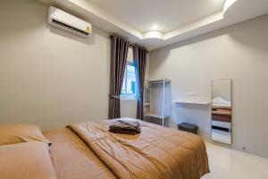 Habitación de hotel con cama y espejo en Norway Poolvilla en Cha Am