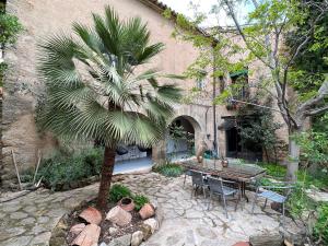 una palmera y una mesa frente a un edificio en Antiguo Molino en Arnes