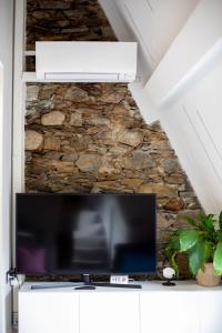 una TV a schermo piatto seduta sopra un armadio bianco di Castello Ripa Baveno a Baveno