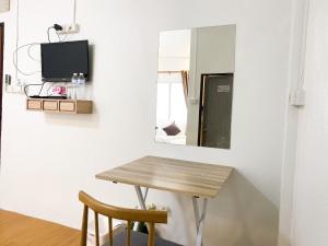 1 mesa y 2 sillas en una habitación con espejo en ฤกษ์ดี RerkDee bed and Breakfast, en Phayao